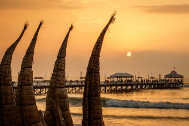 The sunset with traditional boat craft at Huanchaco town, Peru clipart