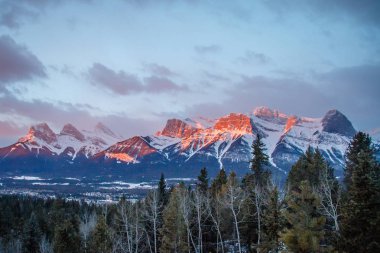 Panoramatic view of mountain range above town of Canmore in Canada clipart