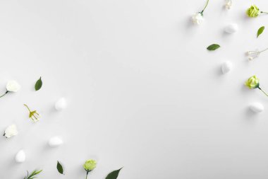 Beyaz arka planda bahar çiçekleri ve yeşil yapraklar. Tomurcuklar ve dekoratif keten, çiçek ve yeşillik kapanıyor. Botanik elementlerle, çiçeklerle ve çimenlerle Paskalya bayramı süslemesi