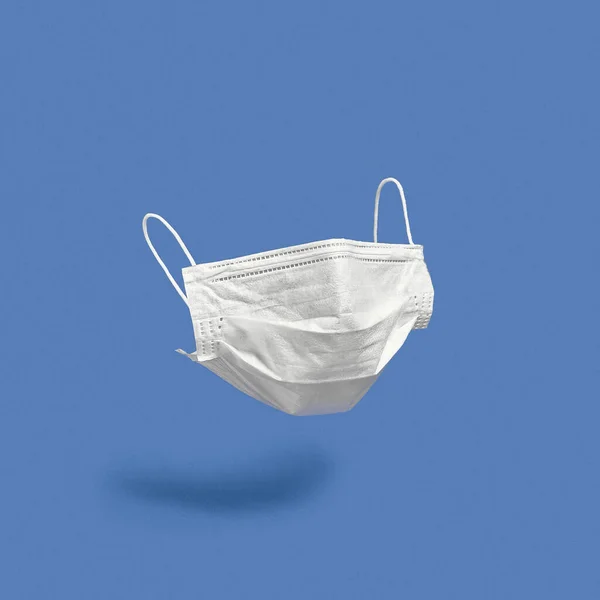 青い背景に外科用フェイスマスク 最小限の医療概念 医療機器 — ストック写真