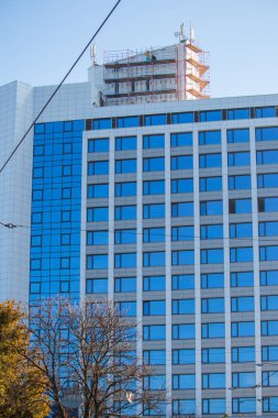 Deniz kıyısında bir park alanına inşa edilmiş ön camlı modern yüksek katlı bina.