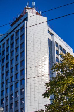 Deniz kıyısında bir park alanına inşa edilmiş ön camlı modern yüksek katlı bina.