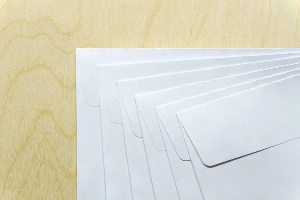 Белые конверты на деревянном столе — стоковое фото
