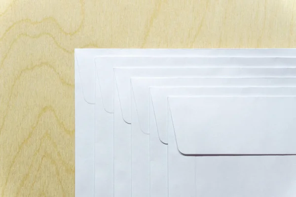 Белые конверты на деревянном столе — стоковое фото