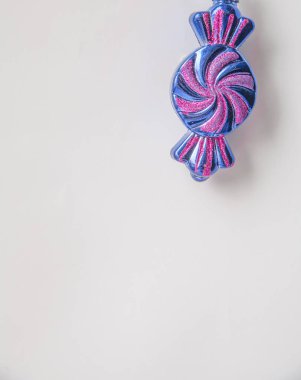 Beyaz arka planda mavi ve kırmızı şeker şeklinde bir Noel oyuncağı.