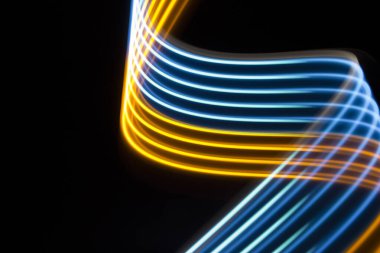 Siyah arkaplanda sarı ve mavi ışık eğrisi çizgileri