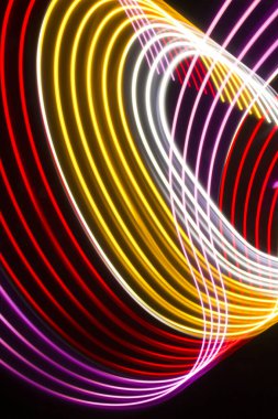 Siyah zemin üzerinde sarı, kırmızı ve pembe ışık eğrileri