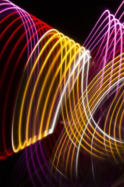 Siyah zemin üzerinde sarı, kırmızı ve pembe ışık eğrileri