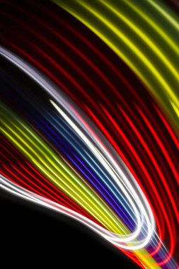 Siyah zemin üzerinde sarı, kırmızı ve mavi ışık eğrisi çizgileri