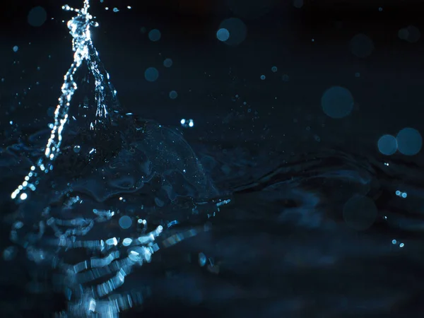 Water Spat Een Donkere Achtergrond — Stockfoto