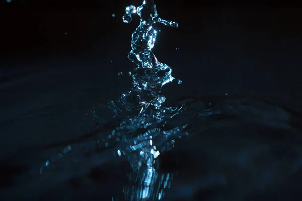 Wasser Plätschert Vor Dunklem Hintergrund lizenzfreie Stockfotos