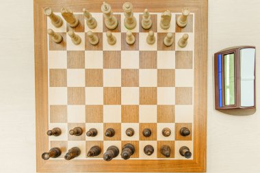 Oyundan önce sıralı rakamlar ve bir saat içeren satranç tahtası