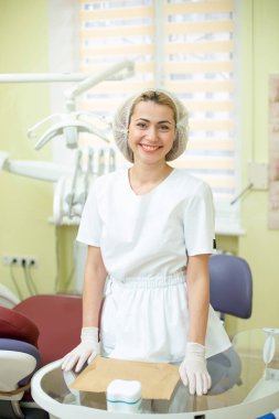 Ofisindeki dişçi doktor aletlerin yanında.