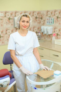 Ofisindeki dişçi doktor aletlerin yanında.