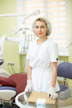 Ofisindeki dişçi doktor aletlerin yanında.