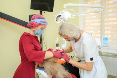 Diş hekimi bir asistanla hastayla manipülasyon yapar.