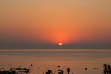 Deniz üzerinde güneş doğuyor tatil köyünde.