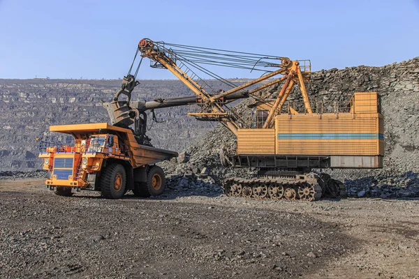 굴착기가 커다란 덤프트럭에 철광석을 나른다 — 스톡 사진
