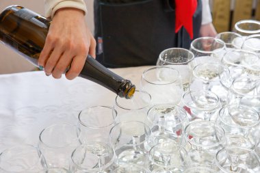 Garson kadehlere şampanya döker.