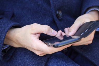 Erkek eli akıllı telefonu tutar.