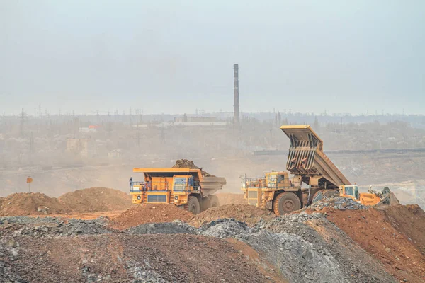 A large mining truck dumps waste rock to a dump