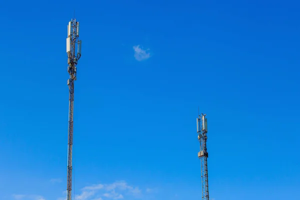 Mavi gökyüzüne karşı iki mobil iletişim anteni