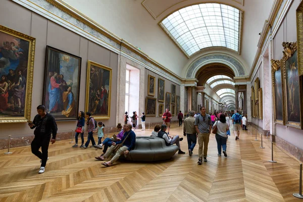 Людей, дивлячись на картини в музей Лувр — стокове фото