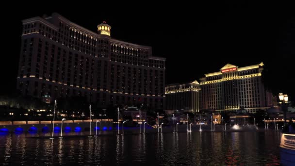 Фонтан Bellagio ночью с видом на отель CaesarsPalace на заднем плане — стоковое видео