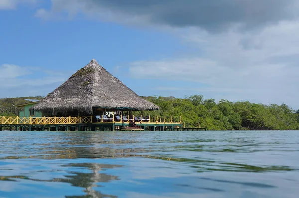 Caribbean restaurant over water with thatched roof