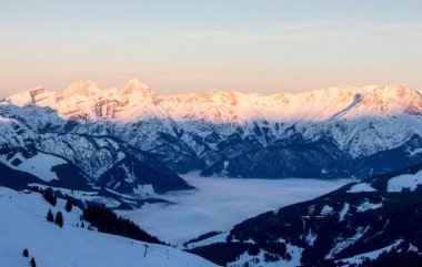 Panoramik manzara Saalbach hinterglemm steinernes Meer kış sisli vadisinde kayak yapıyor
