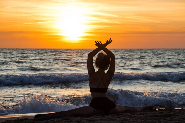 Samotny tancerz balet pozowanie na plaży zachód słońca sylwetka morze — Zdjęcie stockowe