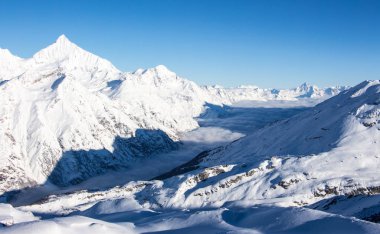 Bulutlar denizi Zermatt Madde Vadisi ve karlı dağlar Kış günbatımı manzarası İsviçre Alpleri
