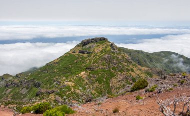 Güzel manzara, ufuk, mavi gökyüzü ve yoldaki tehlikeli bulutlarla Madeira merkez dağlarında yürüyüş yapmak. Muhteşem Madeira dağ manzarası, yeşil ağaçlar, küçük yapılı köyler..