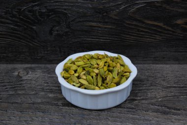 Beyaz bir tabakta yeşil Kardamon tohumları