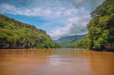 Caon del Sumidero, vista desde una lancha que navega por en medio del rio Grijalva en un dia soleado.
