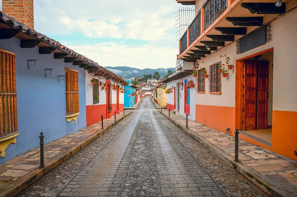 Meksika 'nın San Cristobal De Las Casas şehrinin renkli caddesi Chiapas' ta, arka planda ağaçlık dağlar ve bulutlu bir gökyüzü
