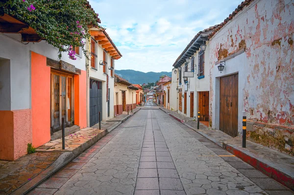 Meksika 'nın San Cristobal De Las Casas şehrinin renkli caddesi Chiapas' ta, arka planda ağaçlık dağlar ve bulutlu bir gökyüzü