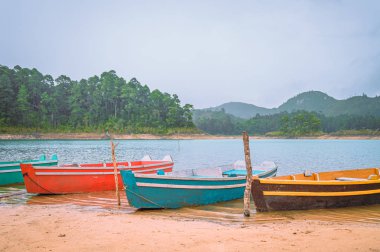 Bulutlu bir günde gölün kenarında renkli tekneler