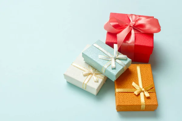 Pastel turkuaz arka planda küçük hediye kutuları var. Noel hediyeleri.
