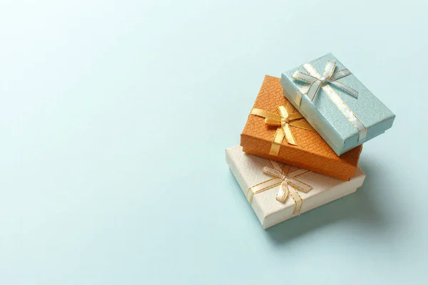 Pastel turkuaz arka planda küçük hediye kutuları var. Noel hediyeleri.