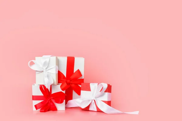 Design de modelo de dia feliz das mulheres. Caixa de presente branca decorativa com arco vermelho sobre fundo rosa pastel . — Fotografia de Stock