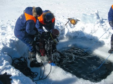 Baykal Gölü, Rusya - 12 Mart 2020: Kurtarma dalgıçları Baykal Gölü 'nde eğitim kampları düzenlediler. Profesyonel dalış ekipmanlarıyla dalgıçlar buzun altına, soğuk suyun altına dalmaya hazırlanıyorlar. Açık hava, kış.