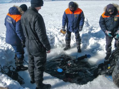 Baykal Gölü, Rusya - 12 Mart 2020: Kurtarma dalgıçları Baykal Gölü 'nde eğitim kampları düzenlediler. Profesyonel dalış ekipmanlarıyla dalgıçlar buzun altına, soğuk suyun altına dalmaya hazırlanıyorlar. Açık hava, kış.