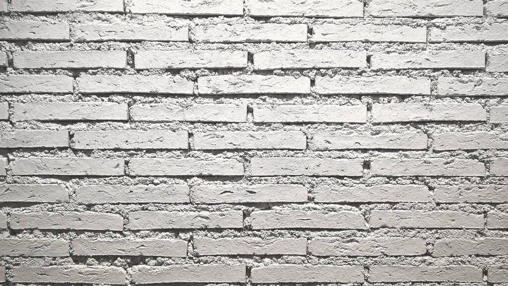 White brick wall background. Abstract weathered texture stained old stucco light gray and aged paint white.