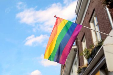 Gökkuşağı Lgbt bayrağı mavi gökyüzüne karşı, hoşgörü ve kabulün sembolü, çeşitlilik, umut ve özlemin. Flag Lgbt rüzgarda süzülüyor.