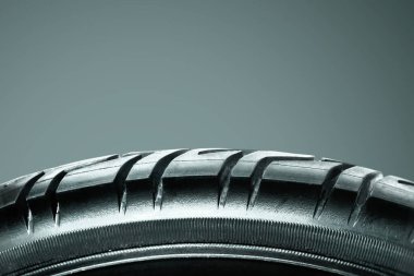 Tires showing for sell or fix in the shop. Tire repair concept. Closeup of damaged car tire. Car wheel in auto repair shop. clipart