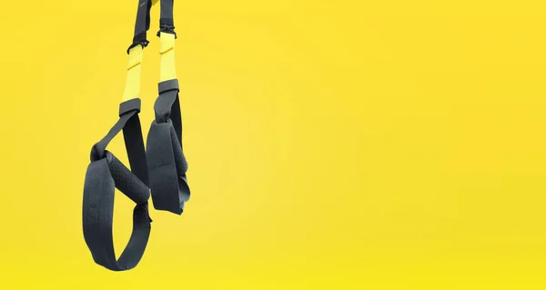 Straps training loop.Functional training equipment on yellow background. Sport accessories.