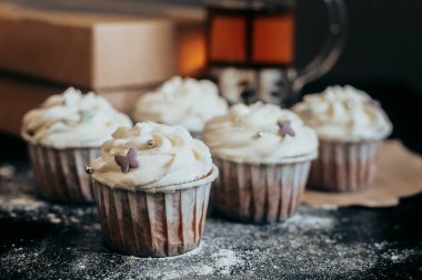 Taze kekler karanlık bir masada duruyor.