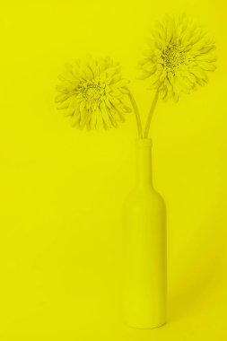 Sarı hayat, sarı arka planda bir şişe şarap ve çiçekle