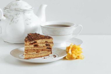 Beyaz bir tabakta kremalı kek dilimi. Parlak renklerde.